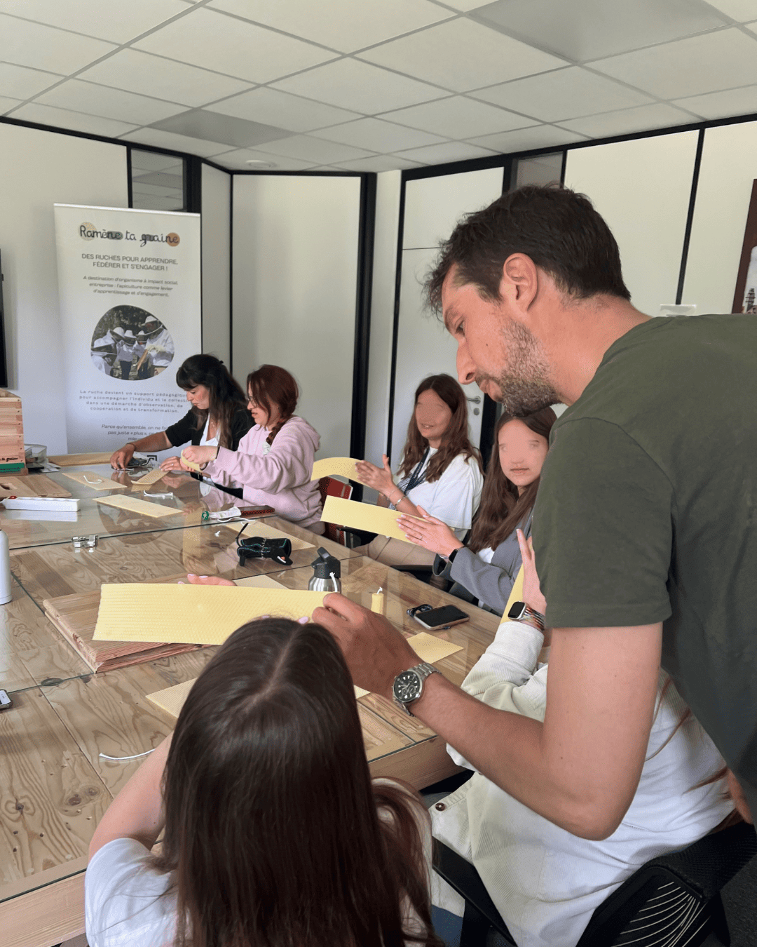 Groupe de participants autour d’un apiculteur pendant une animation abeilles en équipe
